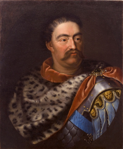 Portret Jana III Sobieskiego w skórze lamparciej. Król sportretowany został w karacenie, spod której spływają pteryges (dekoracyny pas skóry lub tkaniny) zdobione naprzemiennie metalowymi lwimi maskami i głowami polskich orłów heraldycznych. 