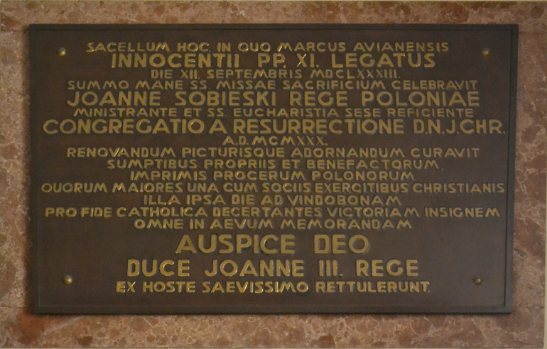 Tablica upamiętniająca Mszę św. na Kahlenbergu 12 września 1683 oraz prace konserwatorskie i malarskie w Kaplicy Sobieskiego. Marmurowa tablica ma łacińską inskrypcję.