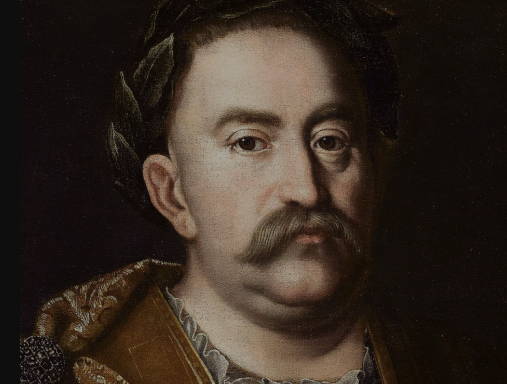 Portret olejny króla Jana III Sobieskiego. Król patrzy poważnie przed siebie. Ma na głowie wieniec laurowy.